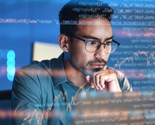 Man in glasses looking pensively at a piece of code