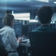 Two tech professionals working in a dimly lit space